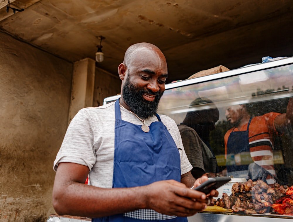 A shop owner checking sales on their phone at the counter